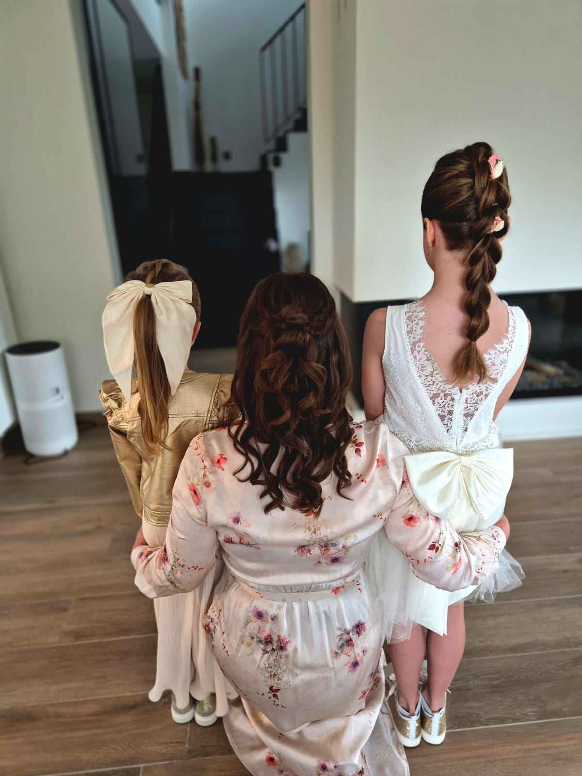 Drie bruidsmeisjes met feestelijke kapsels, van achteren